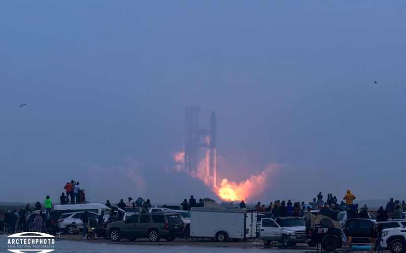 A group of people are watching a rocket launch.