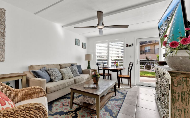 A living room with a couch , table , chairs and a television.
