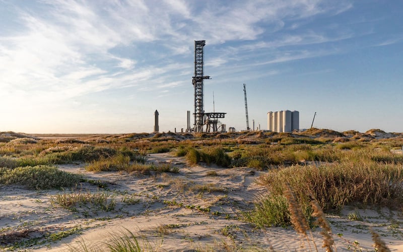 A large building is sitting in the middle of a desert.