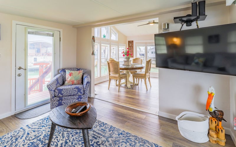 A living room with a table , chairs , and a flat screen tv.