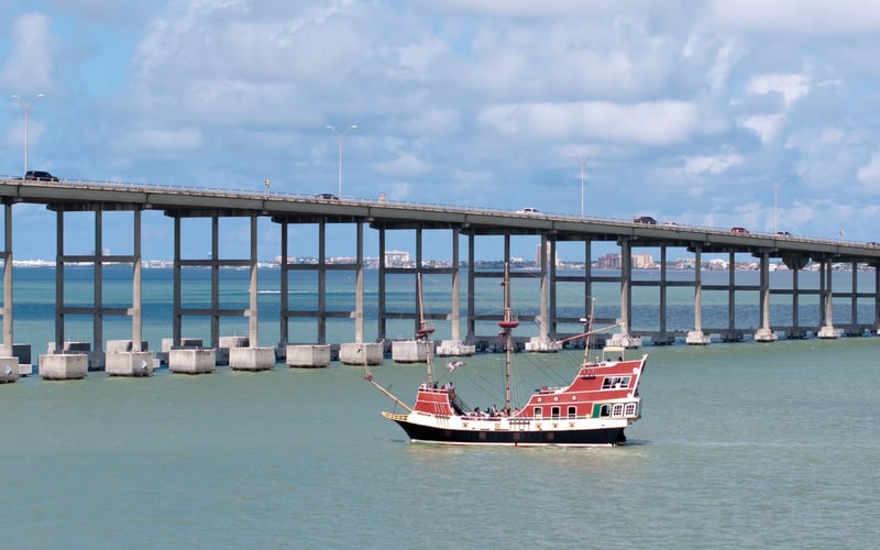 A bridge over a body of water with a boat in the foreground