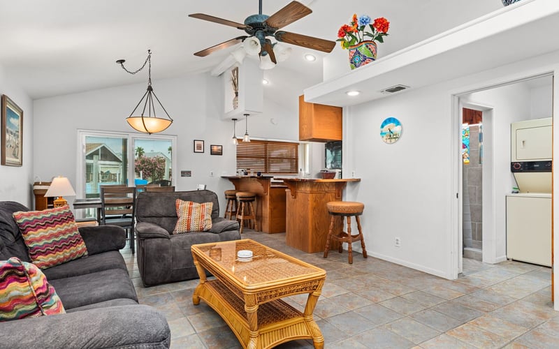 A living room with a couch , chairs , coffee table and ceiling fan.