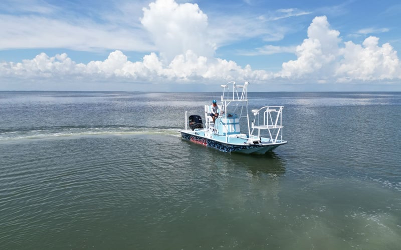 A small boat is floating on top of a large body of water.