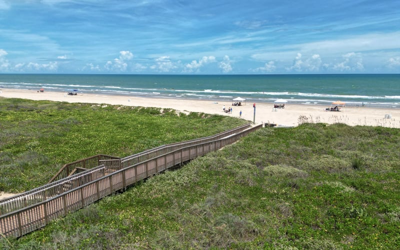 There is a wooden walkway leading to the beach.