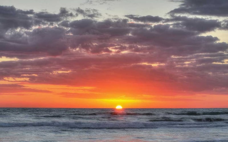 The sun is setting over the ocean.