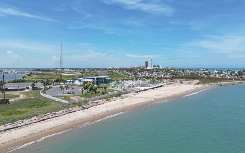 An aerial view of a beach with a city in the background.